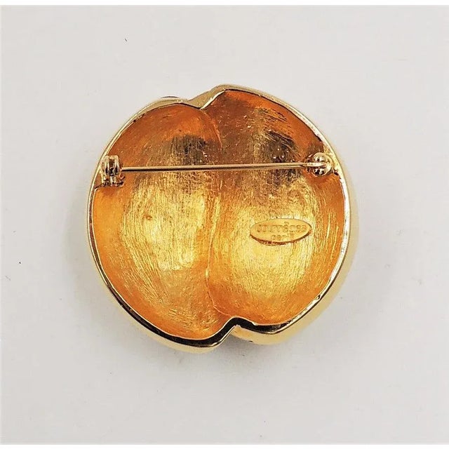 This is part of Chairish’s Costume Jewelry assortment. 1980s goldtone black enamel and clear rhinestone brooch with...