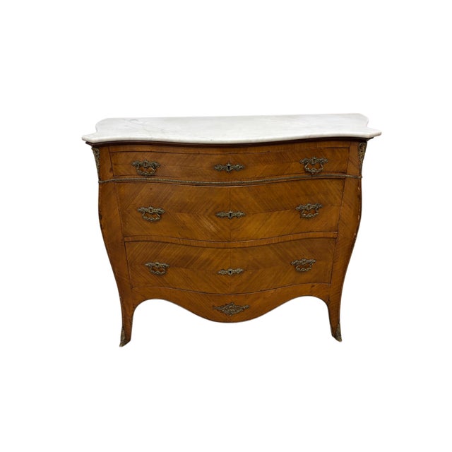 Gracefully shaped in the Louis XV tradition, this elegant French-style bombe commode features beautifully figured walnut...