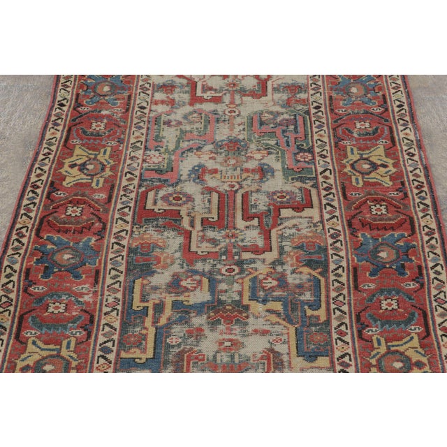 Originating from Northwest Persia circa 1900-1920, this hand-knotted antique wool runner is an exemplary survivor of the...