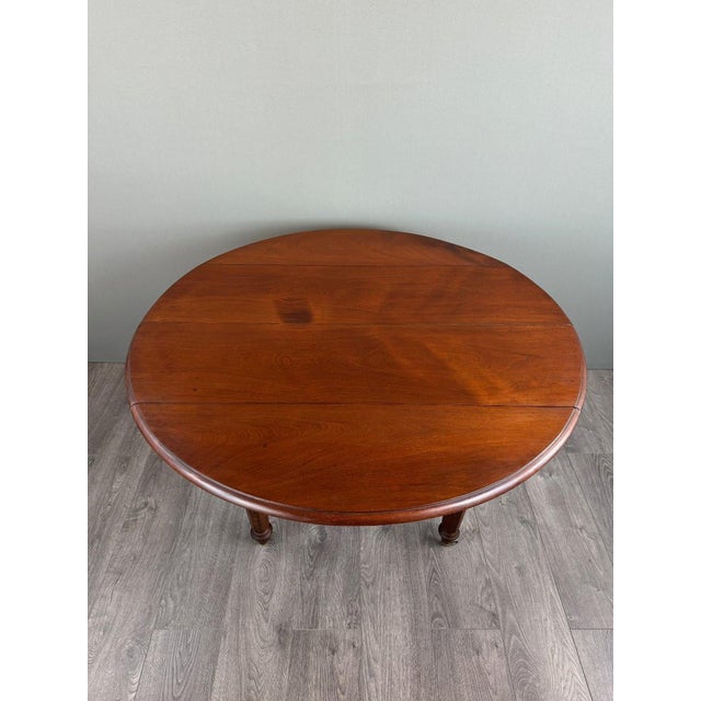 Drop-leaf table in solid wood elegant drop-leaf table in solid wood, resting on four turned legs with brass casters. its...