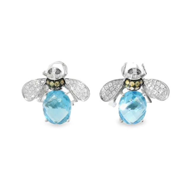Material: 14K White Gold Gemstones: Blue Topaz 6.3 carats total, 9 x 10 mm each, Round and Champagne Diamonds 0.4 carats...