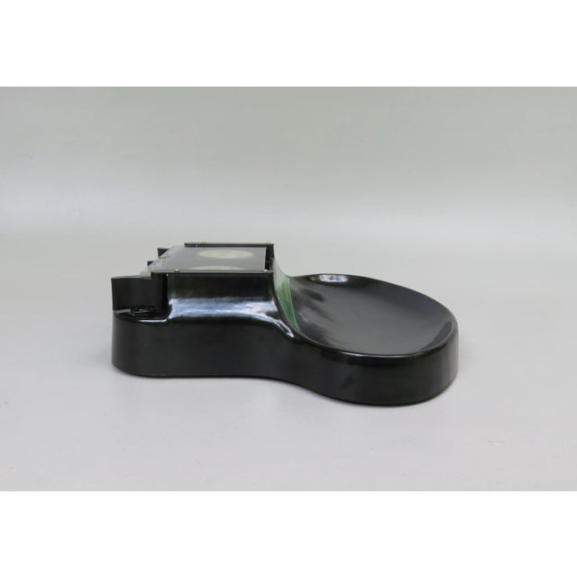 A payments for the shop counter from the 1950s from Bakelit. He is made of bakelite with the advertising letter: \.\. and...