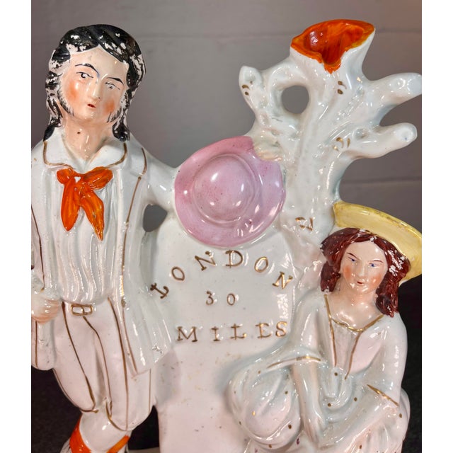 Depicts a man and woman resting by a mile marker indicating the distance to London. Painted in overglaze enamels with gilt...