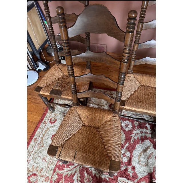 These are Ladder-back (or slat-back) chairs with woven rush seats. This classic design is often associated with Early...