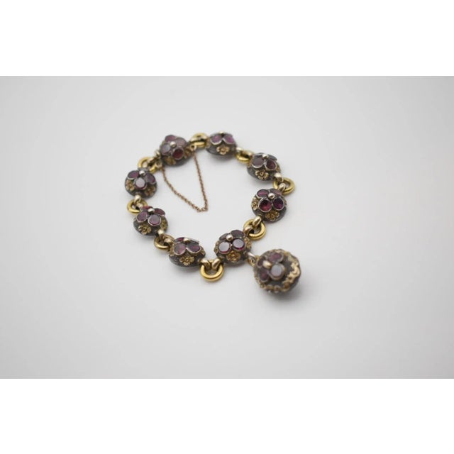 This is a gorgeous antique garnet link bracelet with a locket. Each link is set with a central bed, surrounded by four...