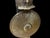 A handmade Turkish brass armor display featuring a tall domed helmet and round shield mounted on a matching pedestal...