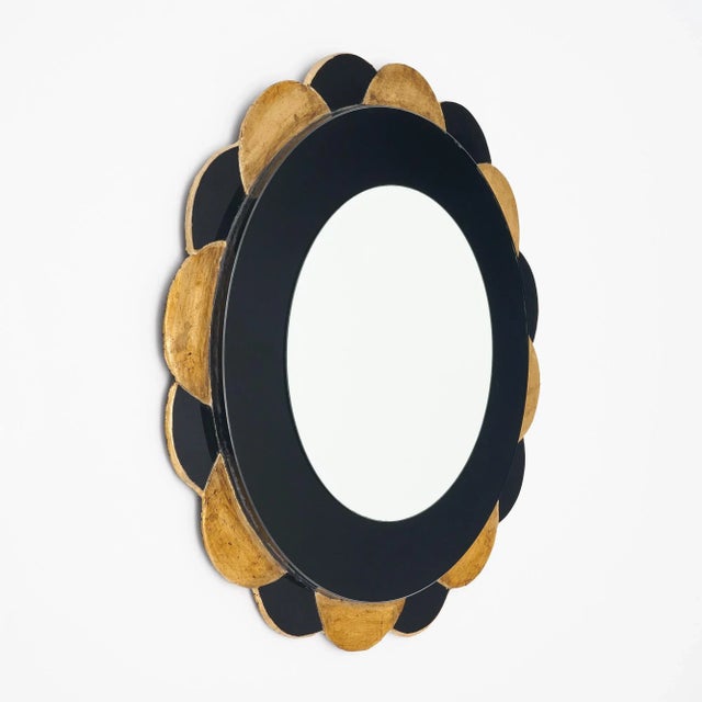 Sunburst mirror from Spain in a Neo Baroque style. This piece has a central circular mirror with a bevel. There is a black...