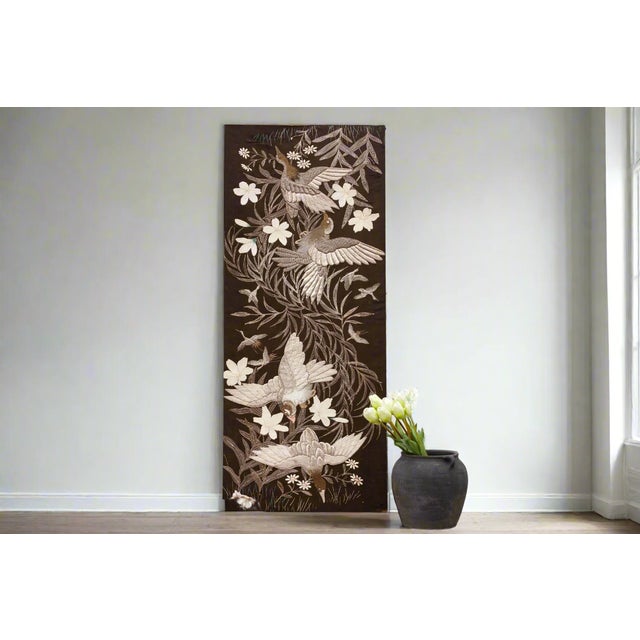 This stunning piece of vintage textile art captures the elegance of birds in flight with intricate embroidery and a rich,...