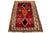 This Persian Shiraz hand-knotted wool rug has a red field with a multicolor geometric design. This rug measures 4'5" x 7'2".