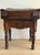 A dark, heavy French butcher block table — the thick plank top banded at each corner with iron strapping secured by hand-...