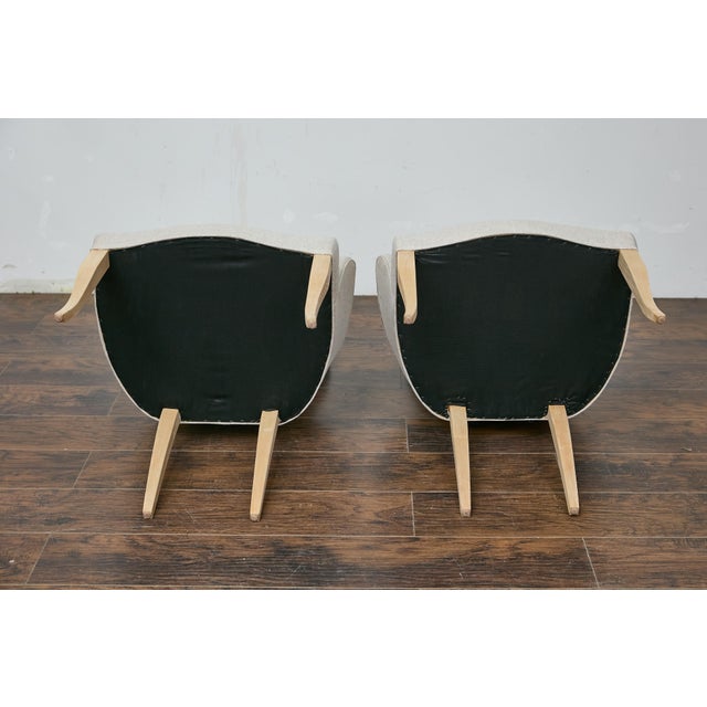 A pair of French Midcentury armchairs with natural tapering legs and custom linen upholstery. This pair of French...