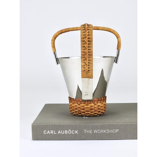 A Mid-Century Modern ice bucket with matching tongs (Model 3703), designed and crafted by Werkstätte Carl Auböck in Vienna...