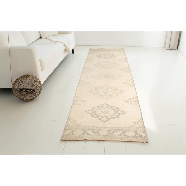 This is a vintage Turkish Oushak rug from the Mid 20th Century. The piece was hand-knotted.