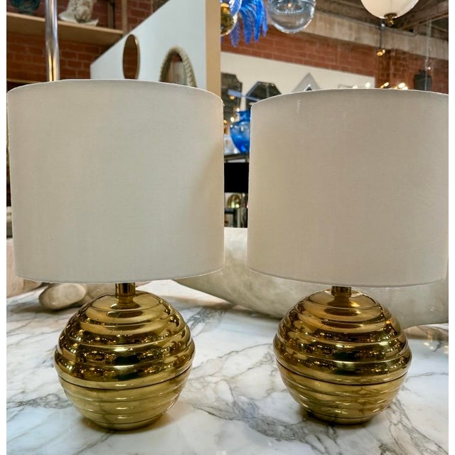 Add a touch of vintage charm and sophistication to your space with this pair of table lamps featuring polished brass...