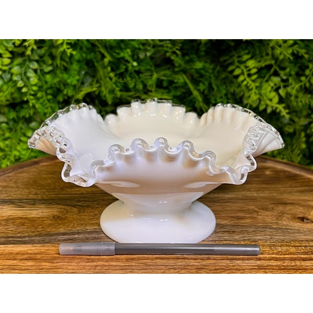 This is a sweet Fenton Art Glass pedestal candy bowl that features a distinctive ruffled clear edge called "Silver Crest."...