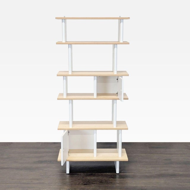 This Oeuf bookshelf features a clean, modern design with five spacious shelves and two white storage compartments. The...