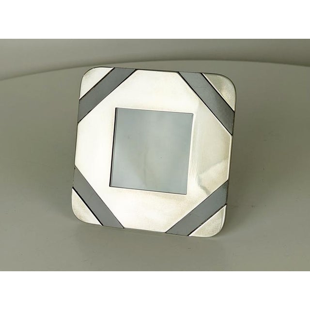 This small picture frame is made from nickel-plated metal with brown plastic inserts and brown velvet back. 2 worked brass...