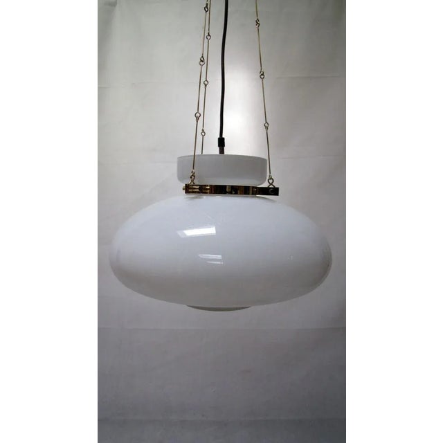 very nice ceiling lamp with white shades and brass This piece is attributed to the mentioned designer/maker. It has no...