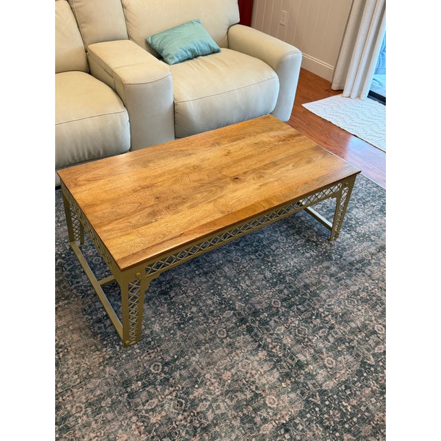 This distinctive West Elm coffee table pairs a beautifully figured natural wood top with an architectural metal base...