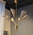 An elegant Mid-Century chandelier in brass and white perforated metal shades. In the manner of Mathieu Matégot, Bent...