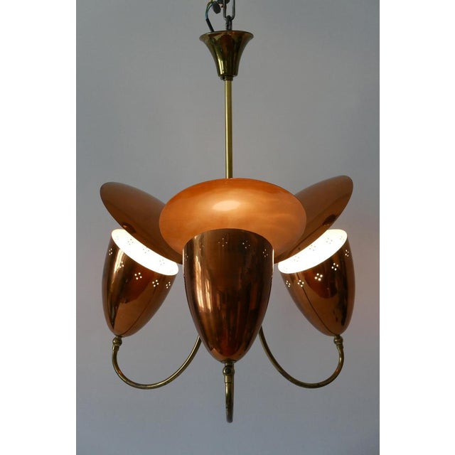 Extremely rare, elegant and highly decorative mid-century modern three-armed pendant lamp or chandelier. Uplighter with...