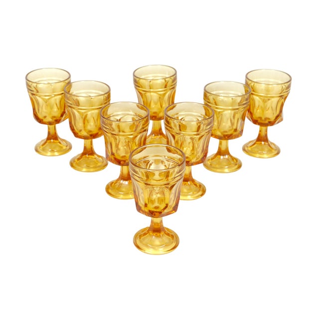 A set of eight Anchor Hocking Fairfield amber glasses. Sculptural cut glasses are decorated with concave sides and a...