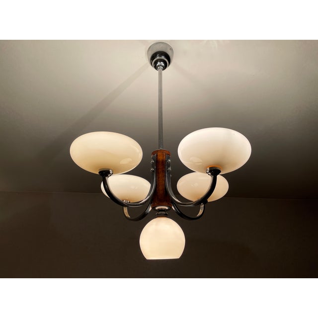 Large Art Deco chandelier from the 1930s, lit by four arms ending in a large pale pink glass shade and a central pink...