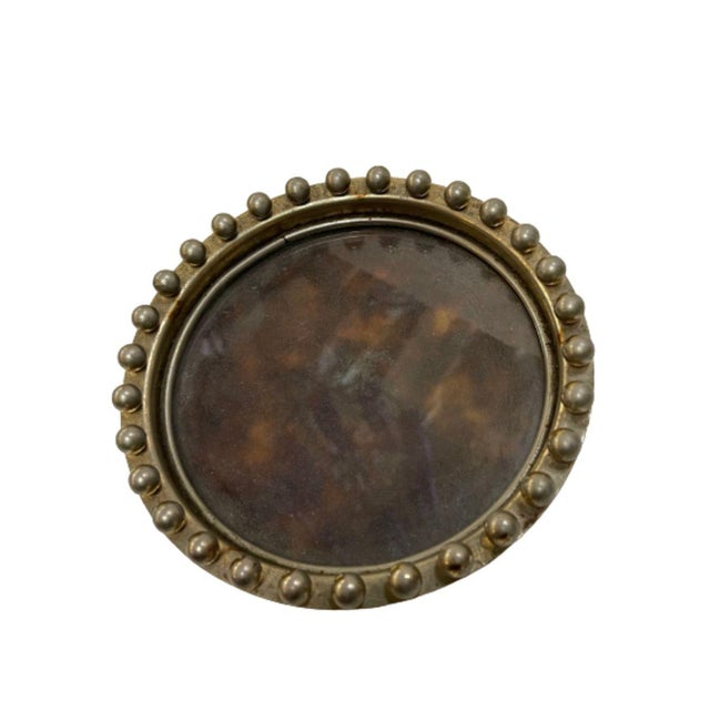 7" diameter hand hammered brass ring tray with faux tortoise shell interior featuring and decorative balls around the...