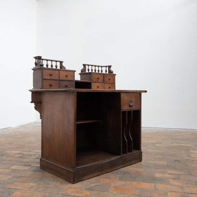Oak pharmacy counter, French work from the early 20th century. Front with molded panels and architectural decoration. Back...