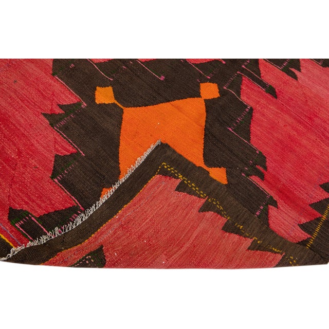 Beautiful vintage Turkish Kilim hand-knotted wool rug with a red field. This piece has multicolor accents in an all-over...