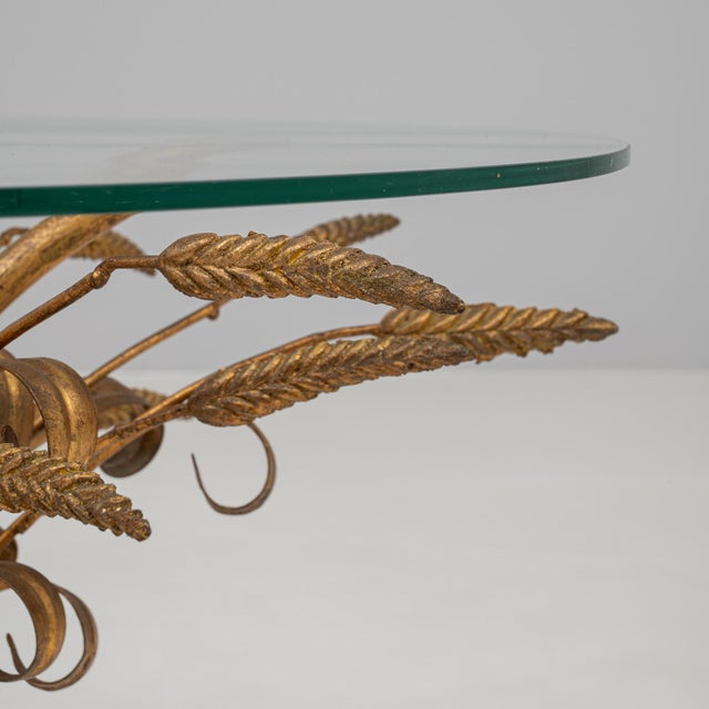 This 20th century Italian coffee table features a sculptural brass base in the form of a sheaf of wheat, a celebrated...