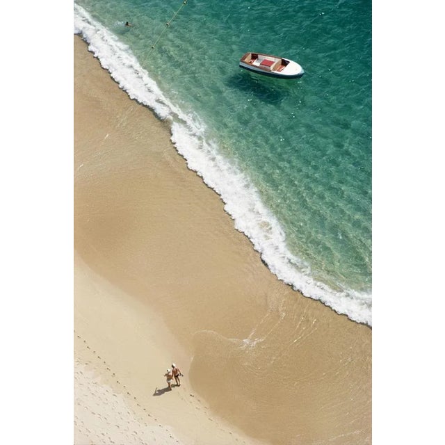 Caleta Beach, Acapulco 1968 by Slim Aarons Slim Aarons Limited Estate Edition A couple walk on Caleta Beach holding hands,...