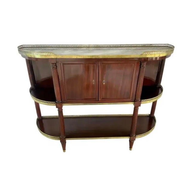 French Louis XVI-Style Mahogany Buffet. Table features a shaped marble top enclosed within a pierced brass gallery, while...