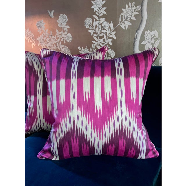 Pink and purple ikat stripes feather into a bold arched motif across these custom throw pillows in Schumacher Bukhara...