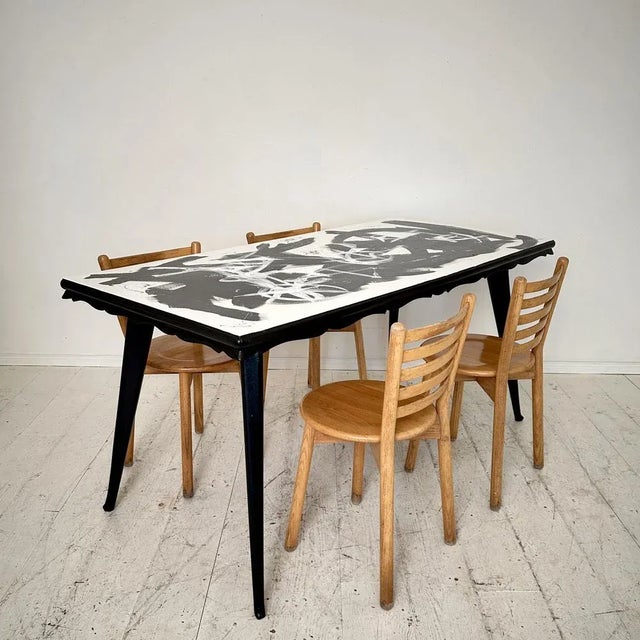 Elevate your dining experience with this striking contemporary abstract painted dining table featuring a 1950s base. The...