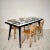 Elevate your dining experience with this striking contemporary abstract painted dining table featuring a 1950s base. The...