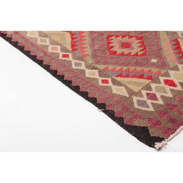 This is a vintage Turkish Oushak rug from the Mid 20th Century. The piece was hand-knotted.