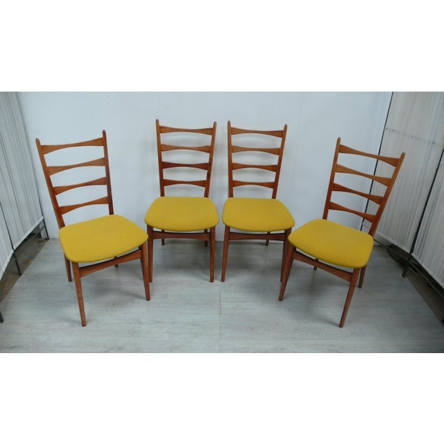 Four chairs from the 1960s with butterfly backrests with four spindles and mustard-yellow upholstery, typical of mid-...
