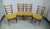 Four chairs from the 1960s with butterfly backrests with four spindles and mustard-yellow upholstery, typical of mid-...
