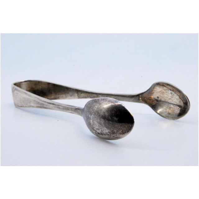 Silver Sugar Tongs with Spoon-Shaped Strips and Tongs, in Very Good conditions. Designed 1920 to 1949 This piece has an...