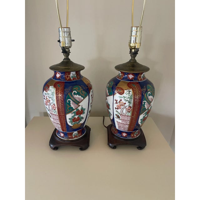Pair of Japanese Imari style table lamps, with a brass fittings and mahogany mounts. New brass finials and harps. In...