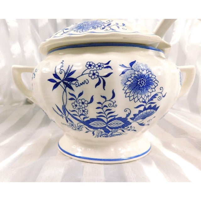 This is an unmarked three piece set of a footed soup tureen, matching lid and white ladle in the Blue Onion pattern. None...
