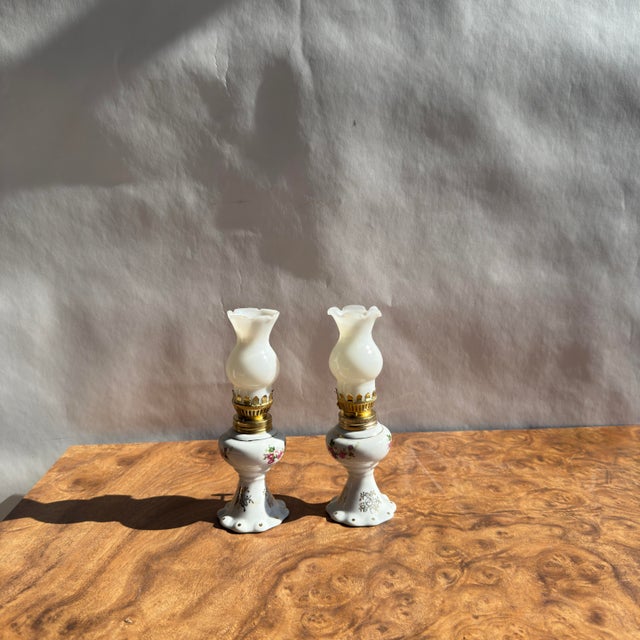 Pair of reproduction milk glass oil lamps in the style of the Victorian era. Both are in good condition. Matching pair....