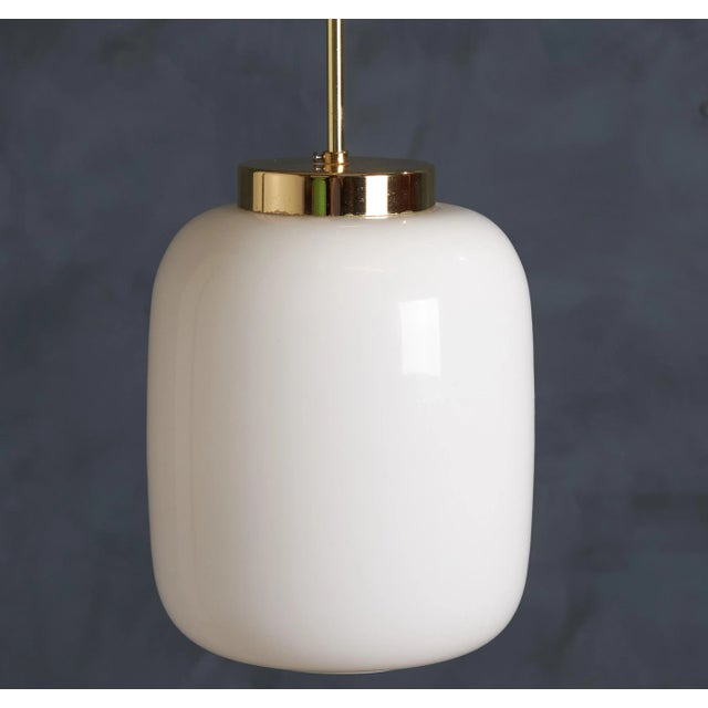 Beautiful pendant lamp in white glass and shiny top in brass. Made in Denmark around the 1960s. The lamp is in great...