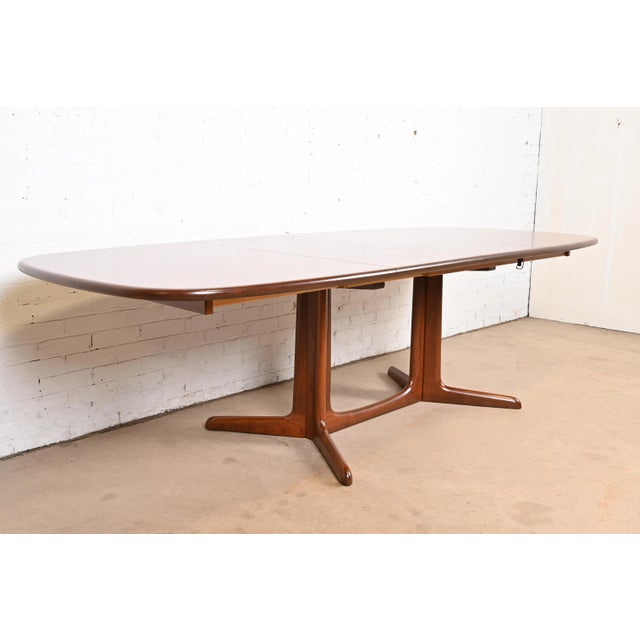 A sleek and stylish mid-century Danish Modern sculpted teak extension dining table By Niels Møller for Gudme Møbelfabrik...