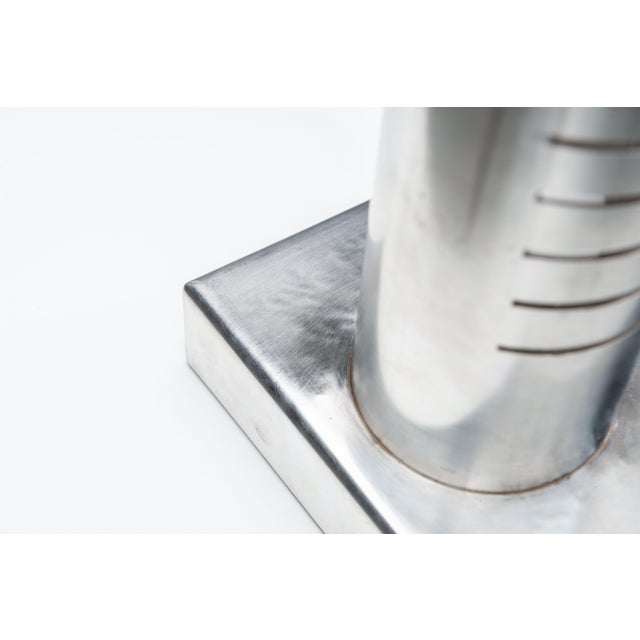 This sculptural table lamp is a refined expression of modernist lighting design. Crafted from brushed stainless steel, the...