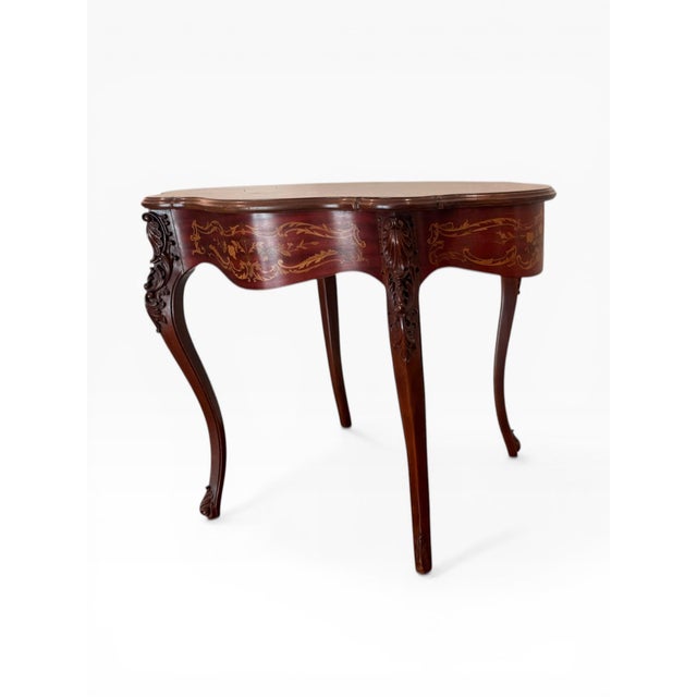 A beautifully crafted Louis XV style console table featuring an elegant serpentine form and richly detailed marquetry top....