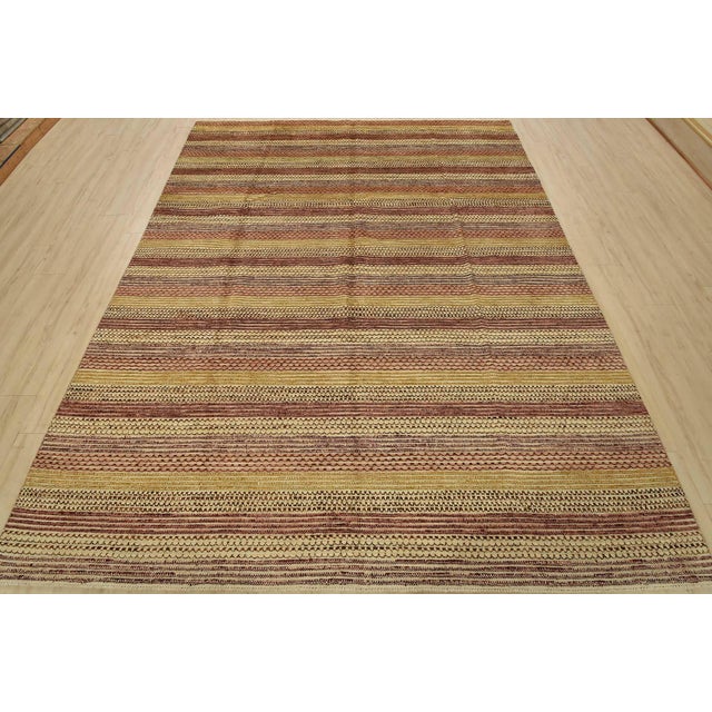 A contemporary Gabbeh rug hand-knotted with fine wool on a cotton foundation. This multicolored rug features stripes...