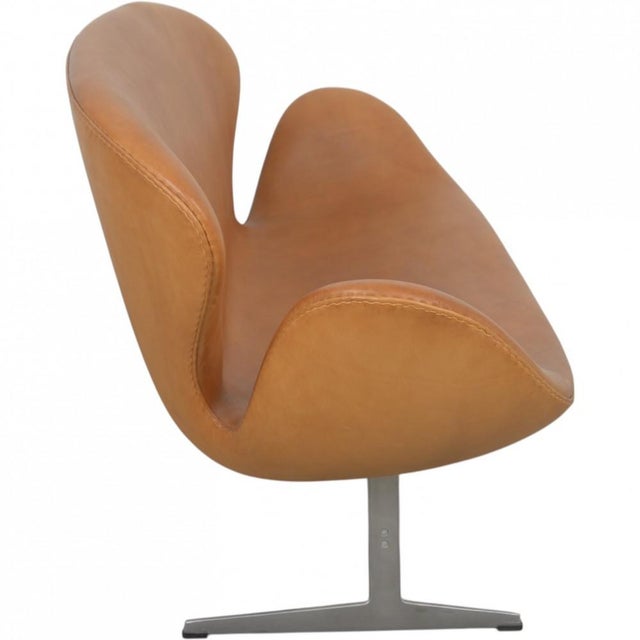 Arne Jacobsen Swan sofa upholstered in cognac anilin leather, and with a brushed aluminium base. The sofa is from 2001,...
