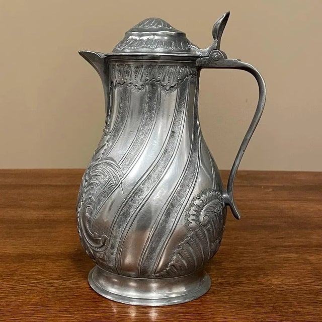 18th Century French Pewter Pitcher is an elaborately decorated example of fine craftsmanship in everyday items, using...